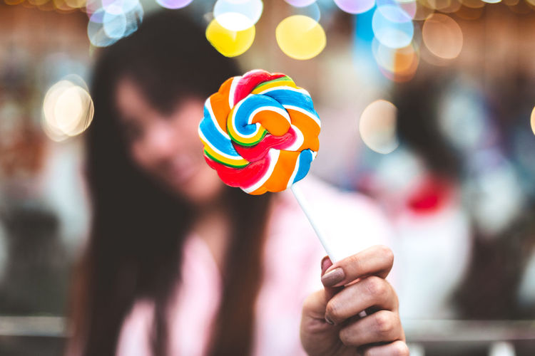 Close-up of woman holding colorful lollipop