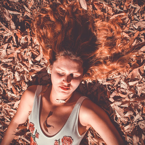 Portrait of young woman lying down on land