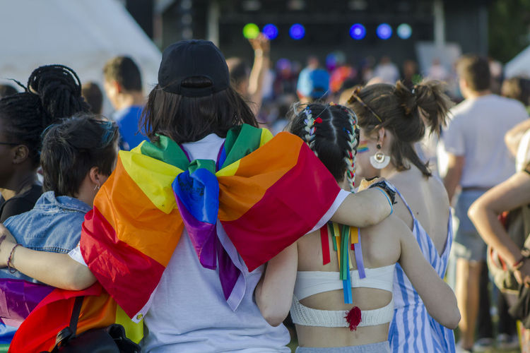 Rear view of women with rainbow flag standing 
