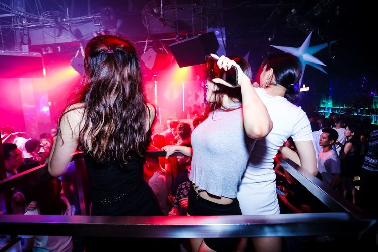 People dancing in music concert at night