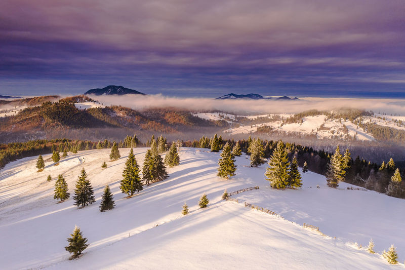 Scenic view of snow covered landscape against sky during sunset