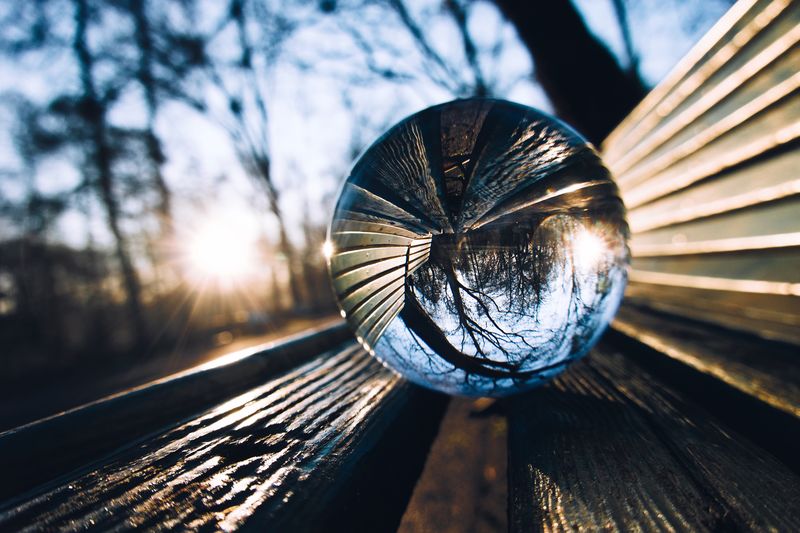 Close-up of crystal ball on wooden bench 