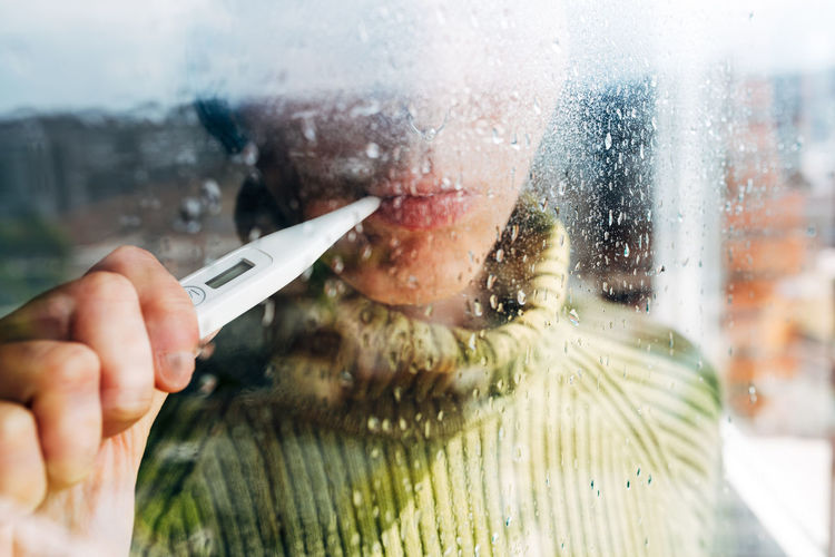 Close-up of man holding glass window