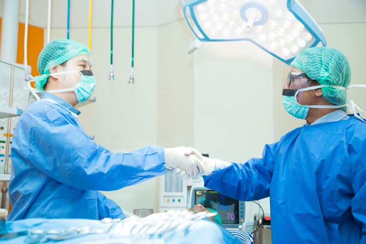 Doctor shaking hand in operating theater