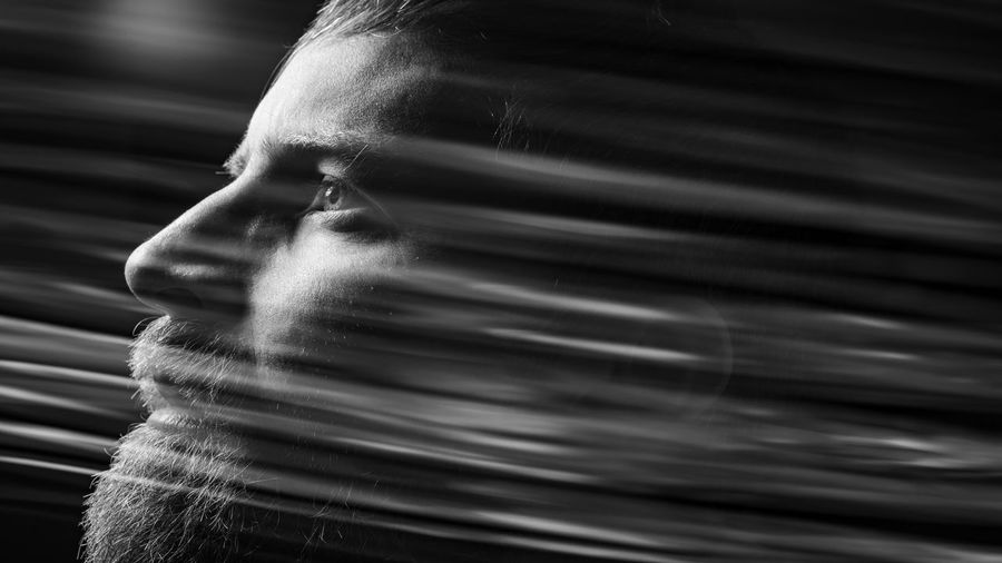 Digital composite image of dissolving thoughtful man against black background