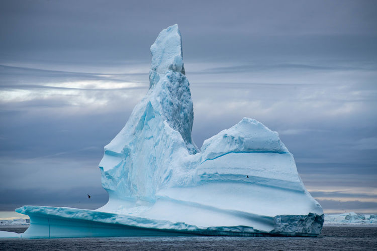 Scenic view of ice berg against sky during winter