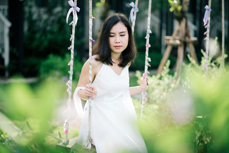 Woman sitting on swing at park