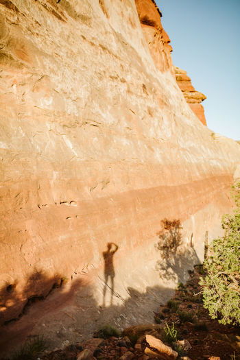 Shadow of photography on red sandstone walls of a canyon wall in utah