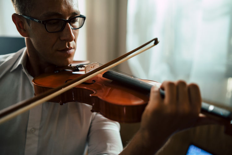 Midsection of man playing violin