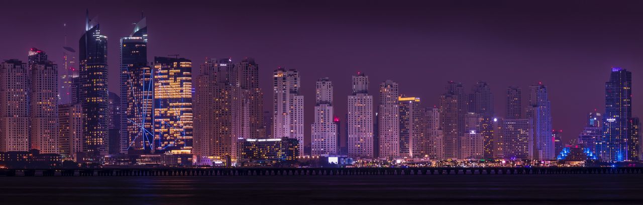 Panoramic view of illuminated cityscape against sky at night