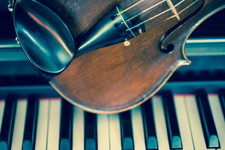 Close-up of violin on piano keys