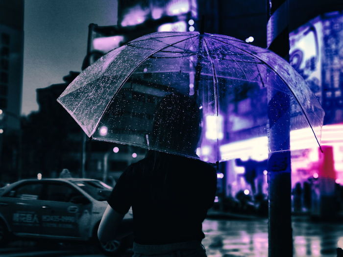 Rear view of man on wet street during rainy season