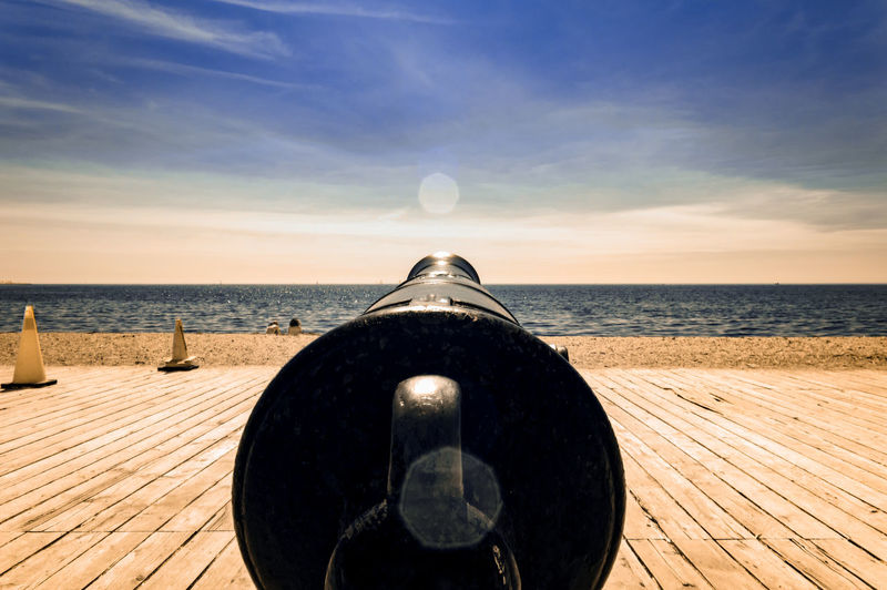 Close-up of cannon on wooden floor at beach