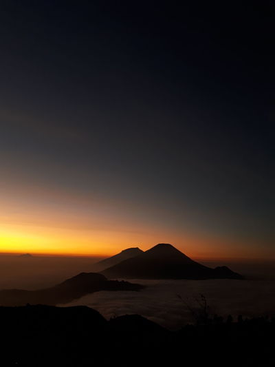 Scenic view of silhouette mountains against sky during sunset