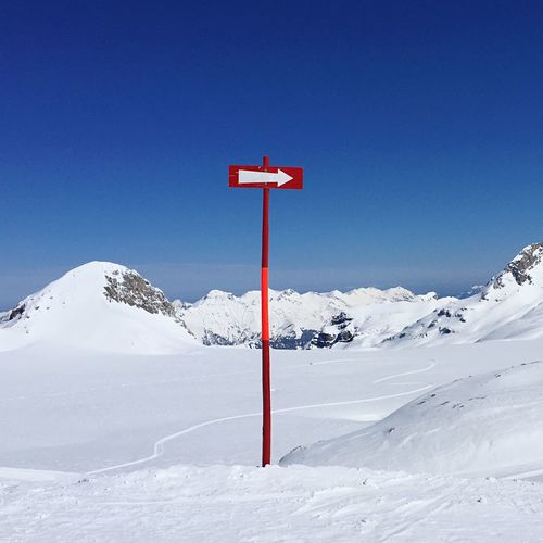 Arrow sign in snowcapped mountains