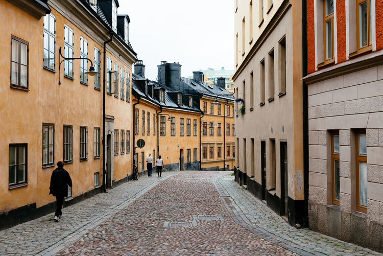 Traditional residential house in stockholm. yellow painted facade against sky.