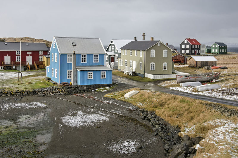 Houses by sea against clear sky