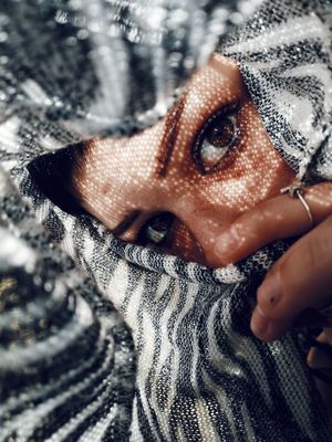 CLOSE-UP PORTRAIT OF A WOMAN COVERING FACE