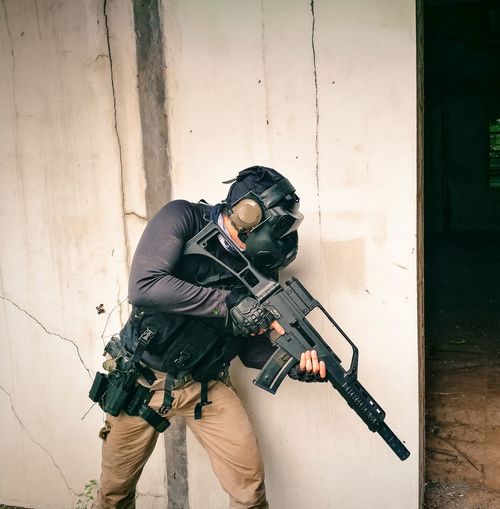 Man with machine gun standing by doorway