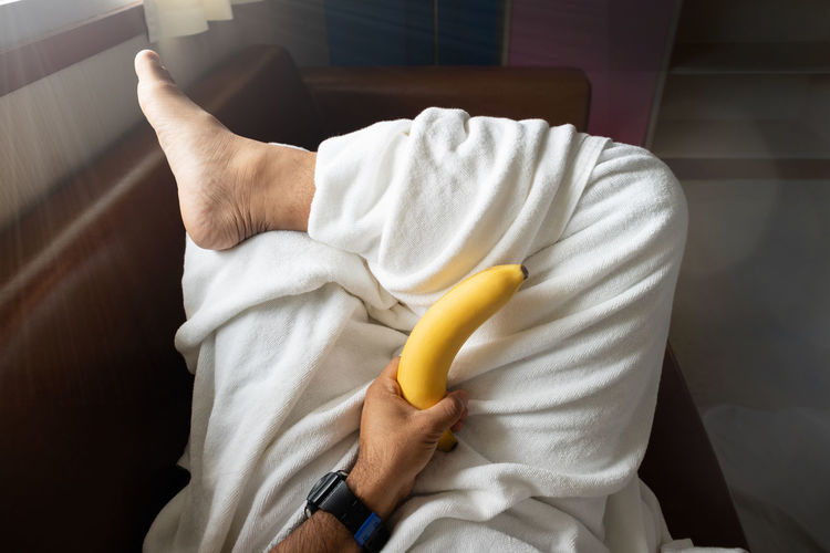 High angle view of man relaxing on bed