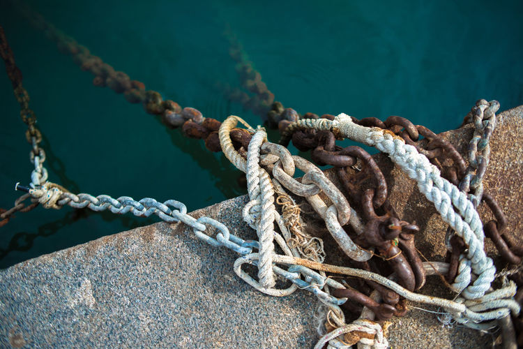 High angle view of ropes and chains on pier at harbor