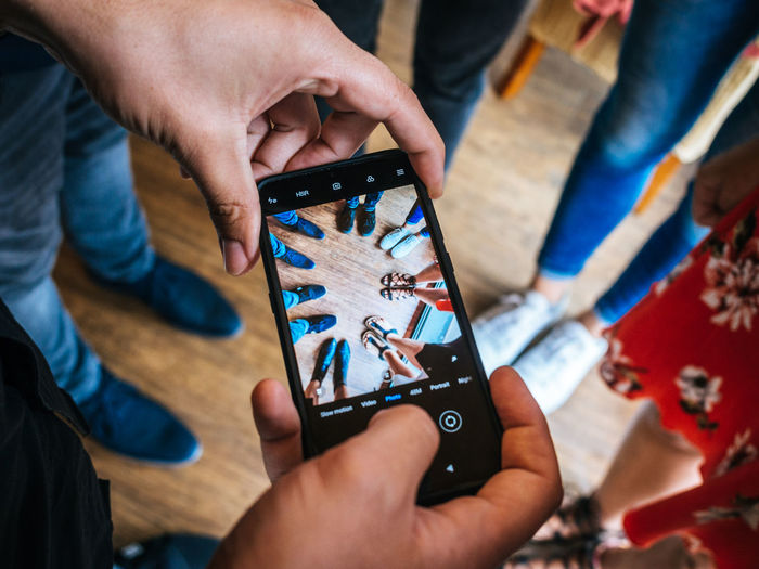 Midsection of man holding mobile phone