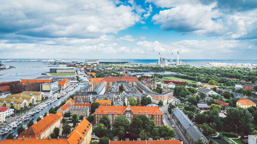 View over copenhagen on a sunny and cloudy day, with colorful roofs and trees