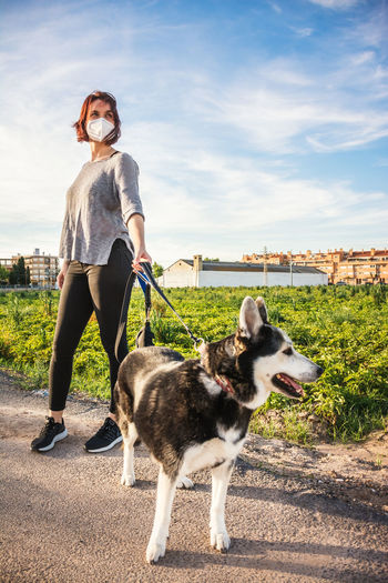 Full length of woman with dog standing against sky