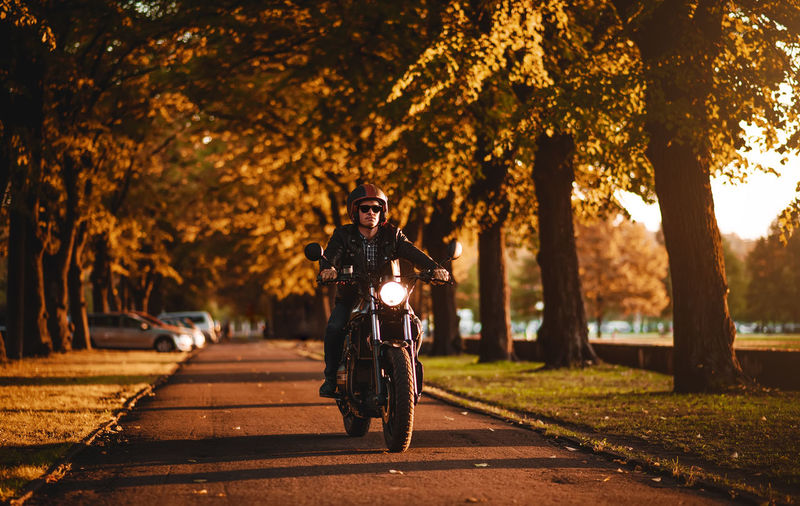 Close-up of man riding motorcycle at sunset