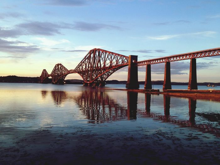 Firth of forth rail bridge over river against sky at dusk