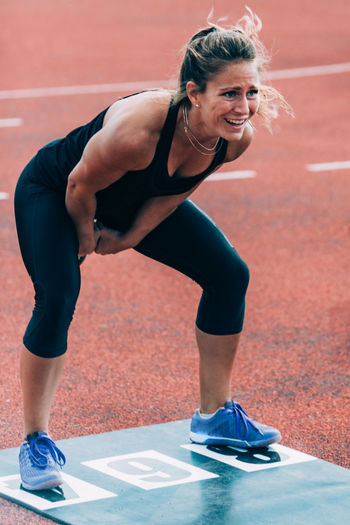 Woman lifting kettlebell on running track