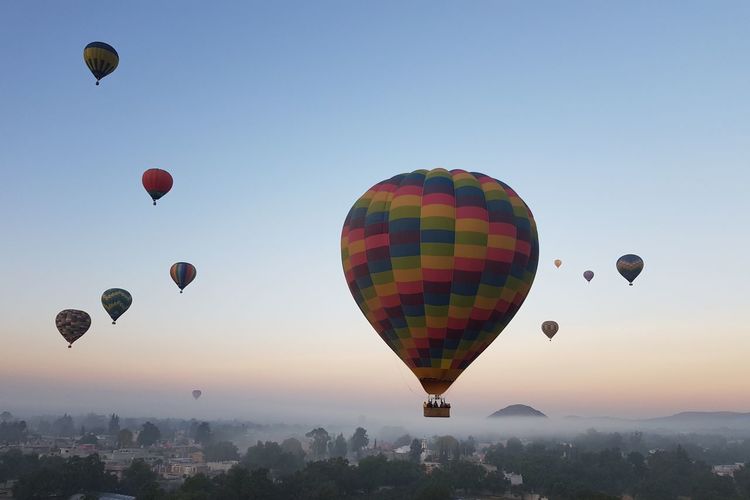 Hot air balloons against sky during sunrise