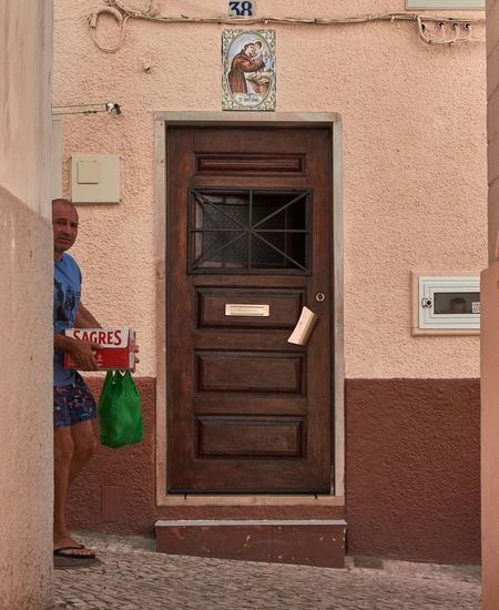 Man standing by door of house