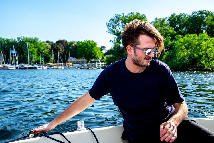 Young man in boat against plants