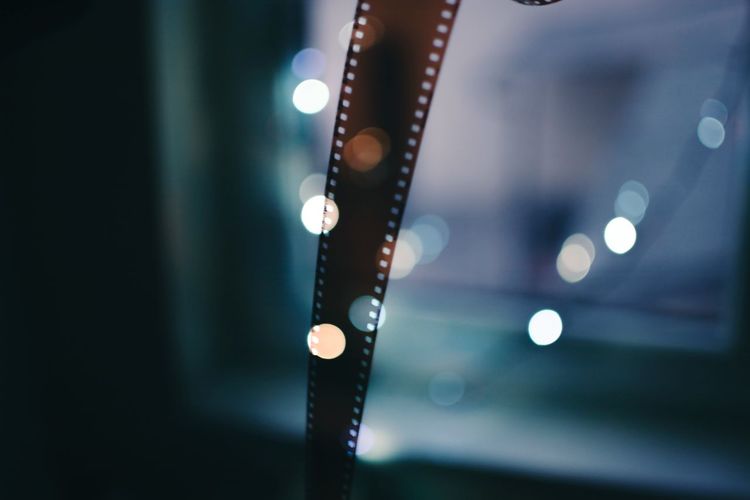 Close-up of film reel against illuminated lights