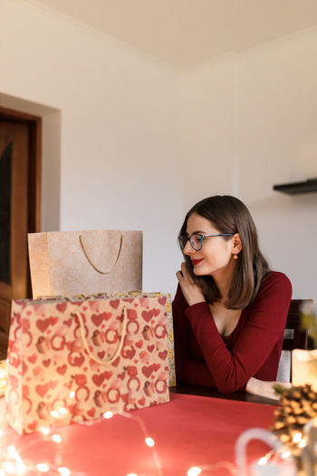 Young millennial woman with christmas presents in a festive atmosphere