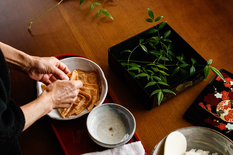 Cropped hands of person preparing food on table.