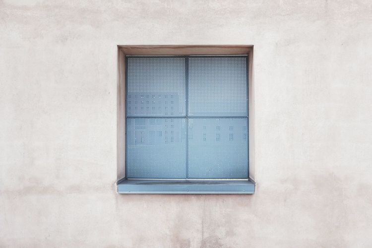 Closed window on white wall of building
