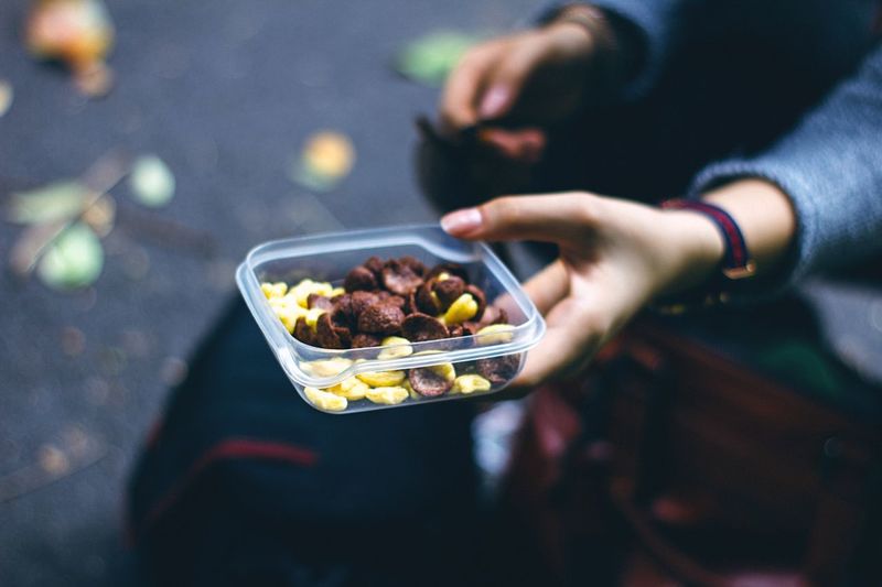 Cropped hand holding breakfast in lunch box