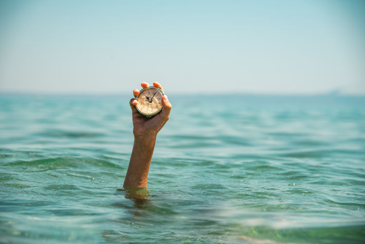 Low angle view of woman swimming in sea against clear sky