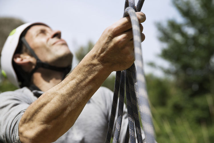 Close-up of mature man holding climbing rope