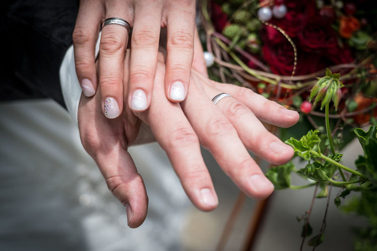 Close-up of couple hand wearing ring during wedding ceremony