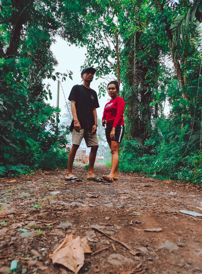 Full length of young couple walking in forest