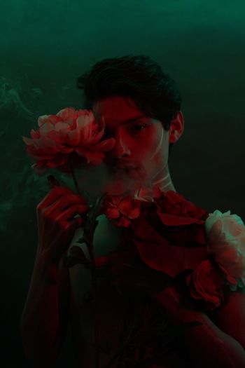 Portrait of man with flowers in darkroom