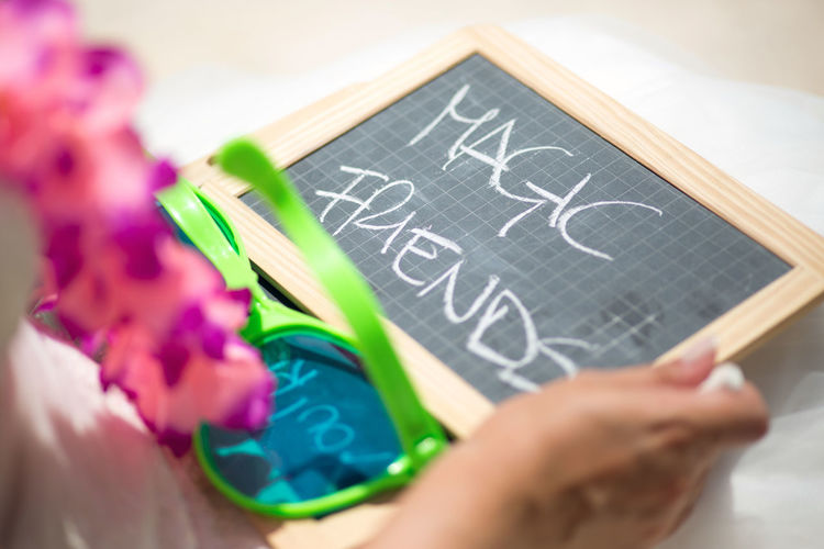 Cropped image of bride holding slate with text