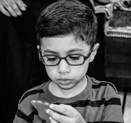 Close-up of boy wearing eyeglasses holding toy