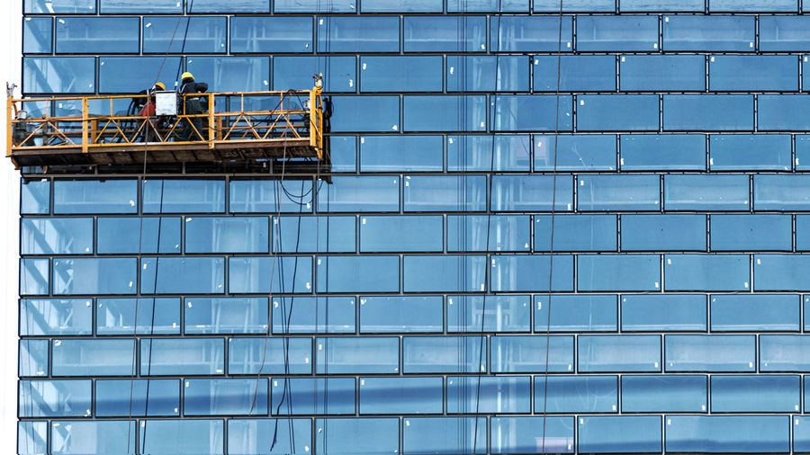 View of workers cleaning office building windows