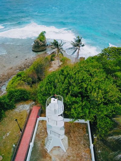 High angle view of statue by sea against trees