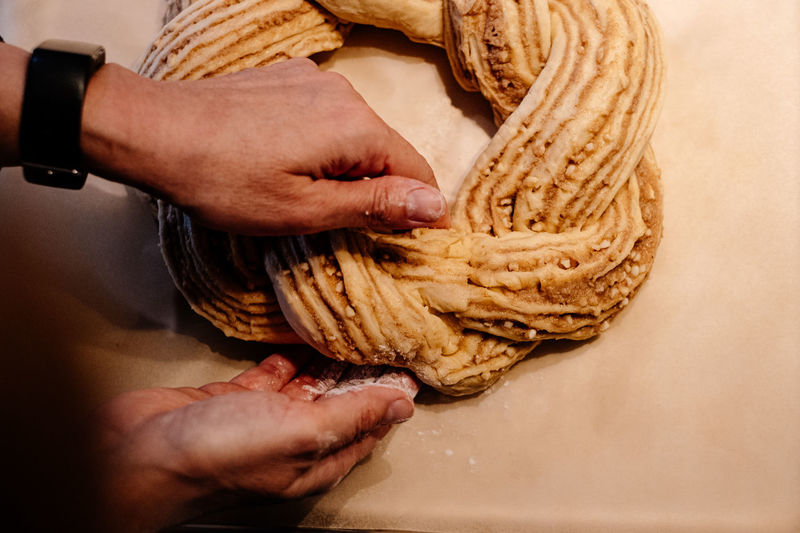 Close up of human hand weaving easter cake dough