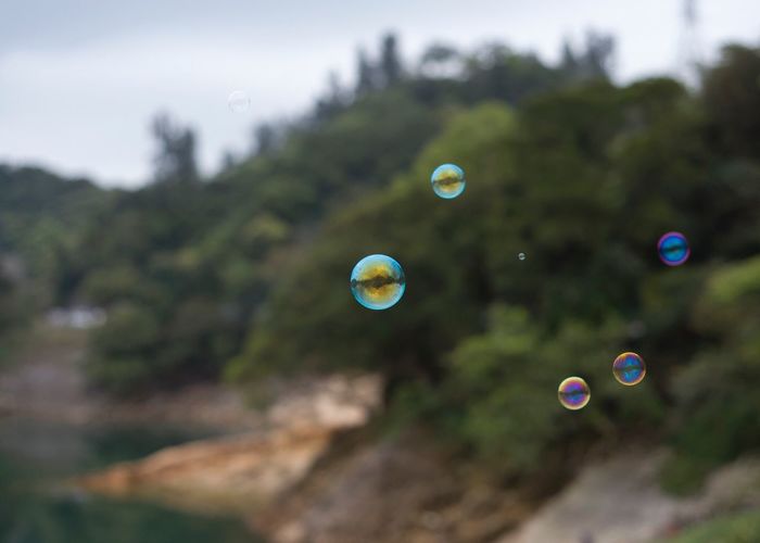 Close-up of bubbles in mid-air against sky